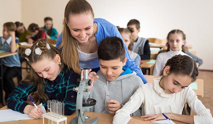 Students,Using,Science,Beakers,And,A,Microscope,At,The,Elementary