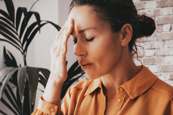 Tired stressed businesswoman feeling strong headache massaging temples exhausted from overwork, fatigued overwhelmed lady executive worker suffering from pain in head or chronic